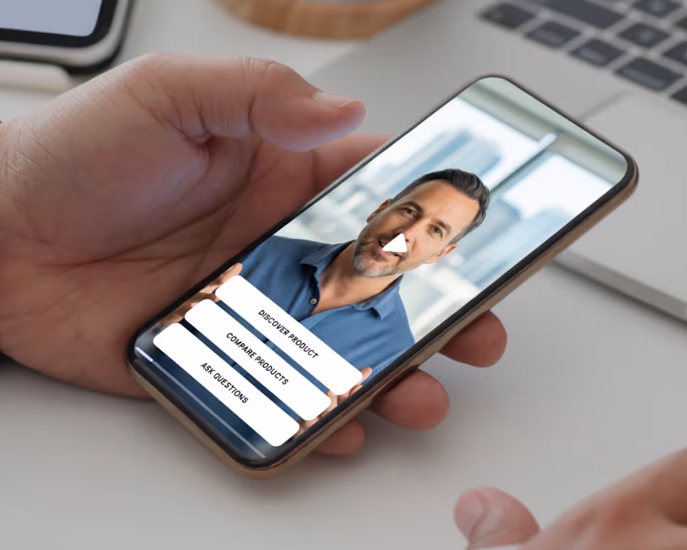 Hand holding a smartphone displaying a paused video of a man with three options: Discover Product, Compare Products, Ask Questions.